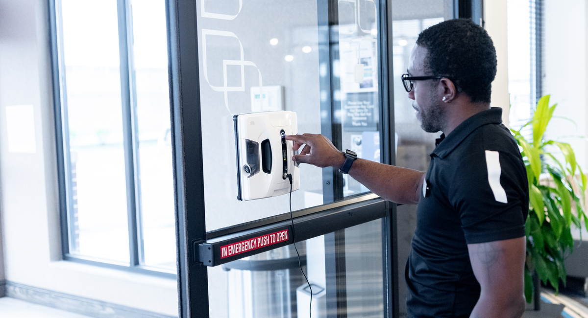 A hotel employee programming a window cleaning robot.