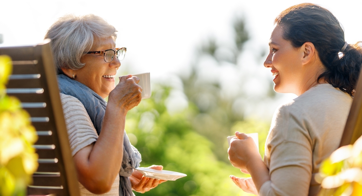 senior lady with caretaker enjoying coffee